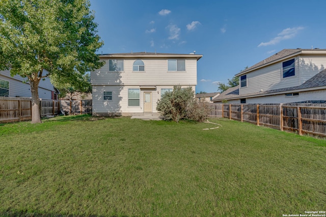 back of property featuring a fenced backyard and a yard