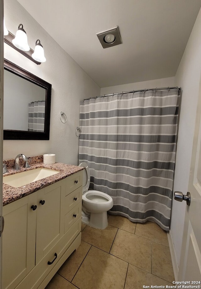 bathroom with vanity, toilet, a shower with shower curtain, and tile patterned floors