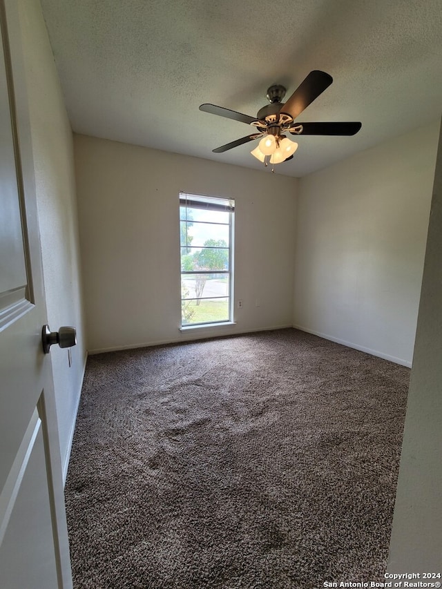 spare room featuring carpet, ceiling fan, and a textured ceiling