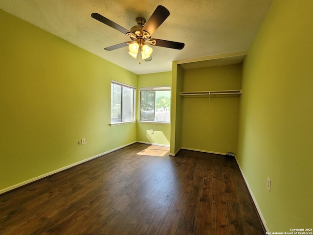 unfurnished bedroom featuring a textured ceiling, dark hardwood / wood-style flooring, ceiling fan, and a closet