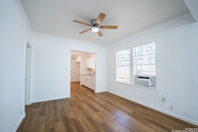 unfurnished bedroom featuring cooling unit, sink, ceiling fan, and dark hardwood / wood-style flooring