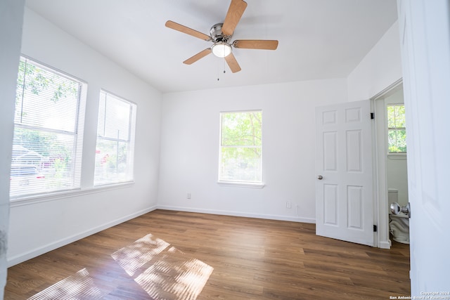 unfurnished room featuring dark wood-type flooring, ceiling fan, and plenty of natural light