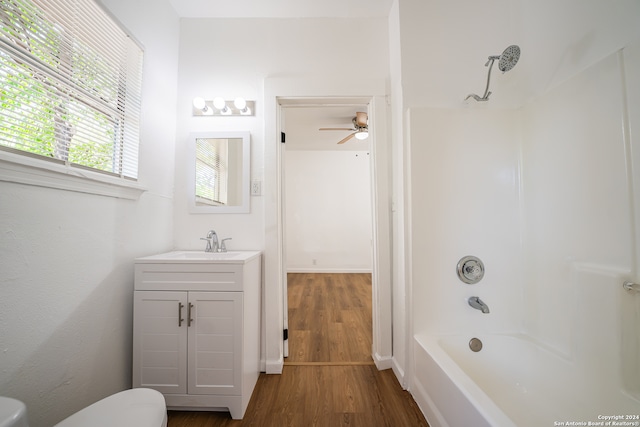 full bathroom with ceiling fan, vanity, wood-type flooring, shower / bathing tub combination, and toilet