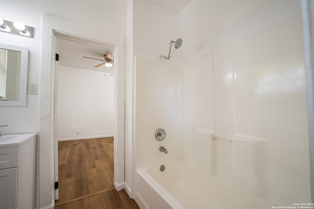 bathroom with vanity, ceiling fan,  shower combination, and hardwood / wood-style flooring