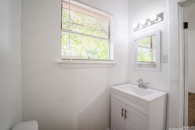 bathroom with vanity, a healthy amount of sunlight, and toilet