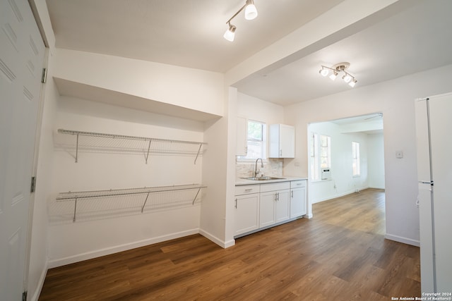 kitchen featuring white cabinets, white refrigerator, dark wood-type flooring, and sink