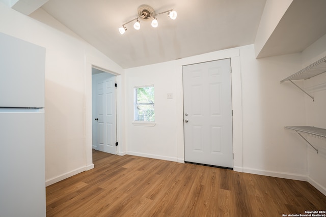 foyer entrance with vaulted ceiling and hardwood / wood-style floors