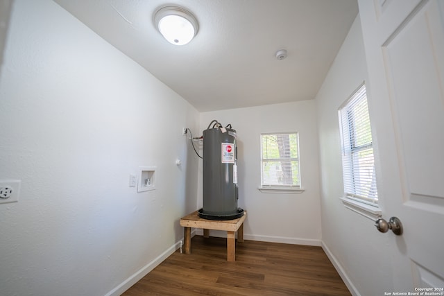 interior space with hookup for a washing machine, electric water heater, and dark hardwood / wood-style floors