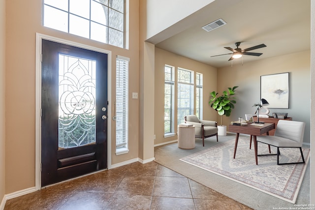 foyer with visible vents, baseboards, ceiling fan, dark tile patterned floors, and dark carpet