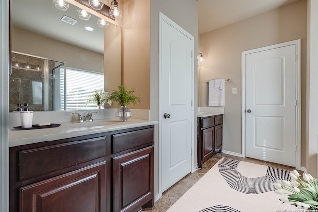 bathroom with tile patterned flooring, vanity, and walk in shower