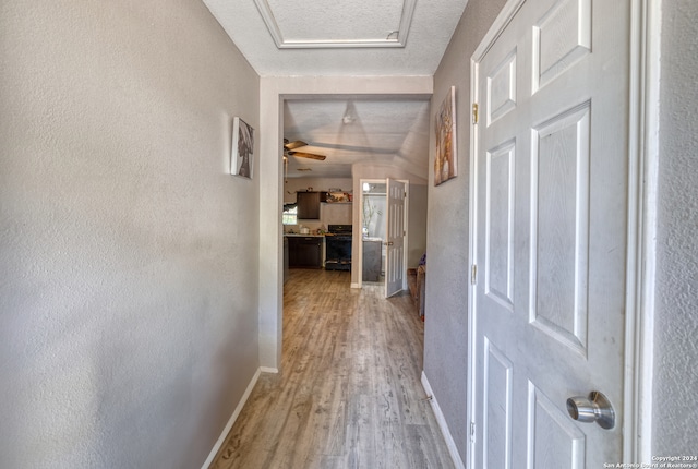 hallway with vaulted ceiling and hardwood / wood-style floors