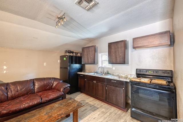 kitchen with a textured ceiling, black appliances, lofted ceiling, light hardwood / wood-style flooring, and sink