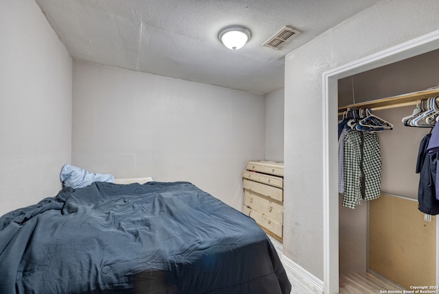 bedroom with a closet and hardwood / wood-style floors