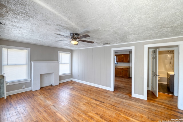 unfurnished living room featuring ceiling fan, a textured ceiling, and light hardwood / wood-style flooring