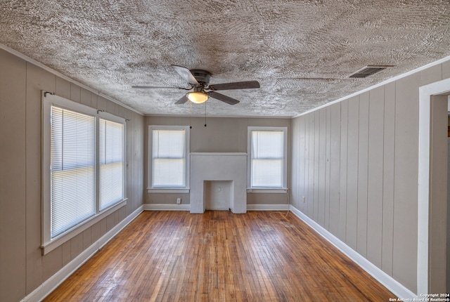 spare room featuring ornamental molding, ceiling fan, hardwood / wood-style flooring, and a textured ceiling