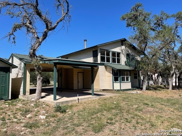 rear view of house with a patio and a yard