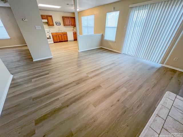 unfurnished living room featuring light hardwood / wood-style floors and sink