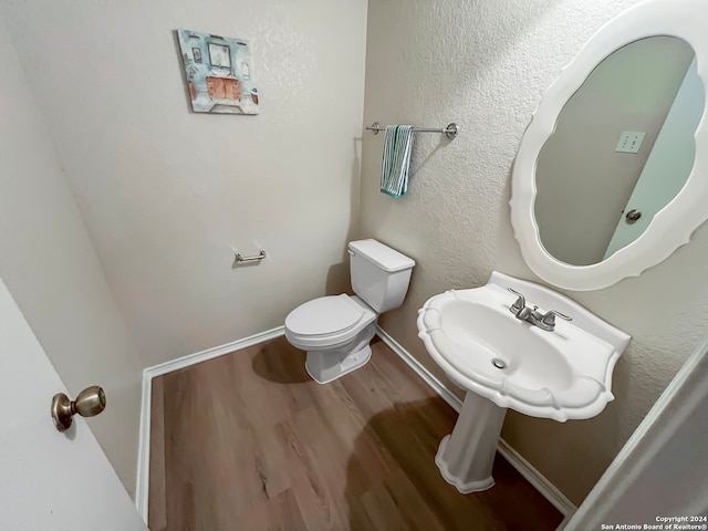 bathroom with hardwood / wood-style flooring and toilet