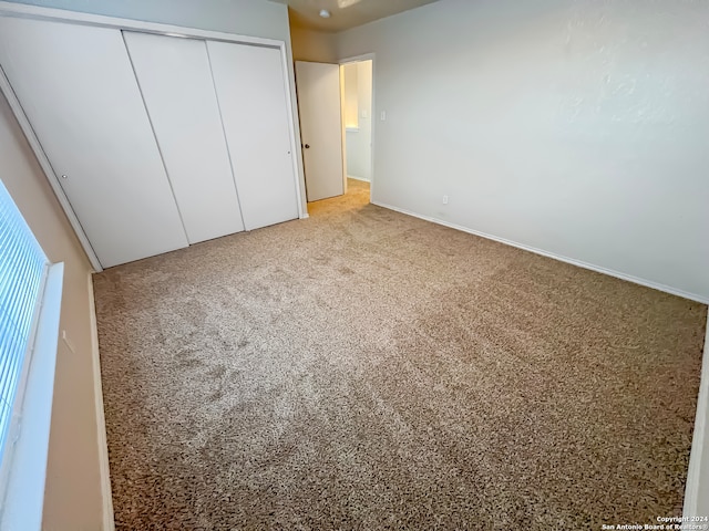 unfurnished bedroom featuring a closet and carpet flooring