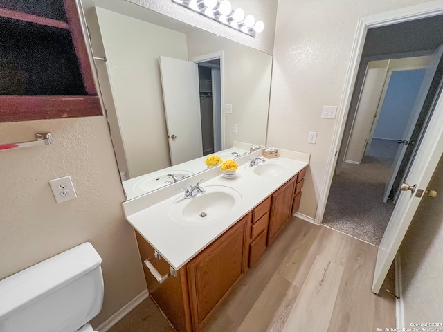 bathroom with hardwood / wood-style floors, vanity, and toilet