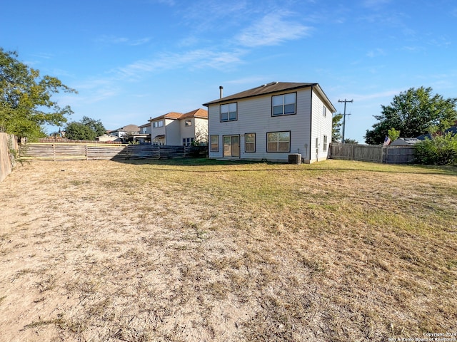 back of property with a yard and central AC unit