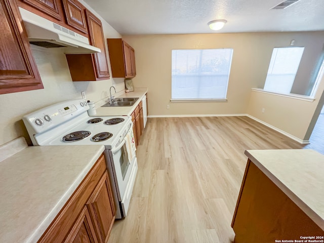 kitchen with light wood-type flooring, a textured ceiling, white electric range oven, and sink