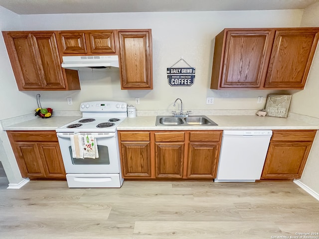 kitchen featuring white appliances, sink, and light hardwood / wood-style flooring