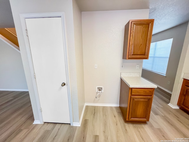 interior space with washer hookup and light hardwood / wood-style floors