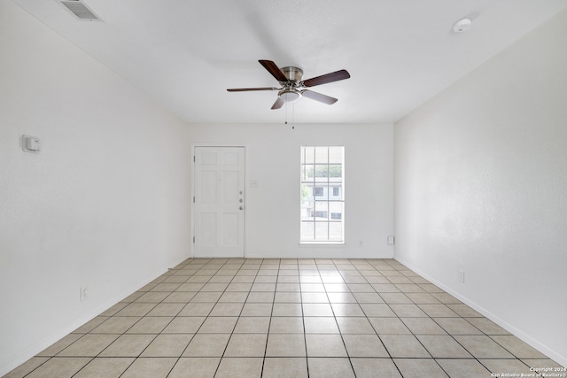 empty room with ceiling fan and light tile patterned flooring