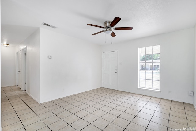 tiled empty room featuring ceiling fan