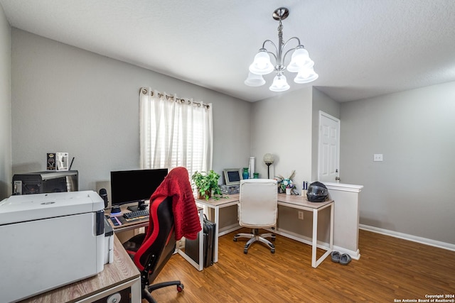 office featuring wood finished floors, an inviting chandelier, and baseboards