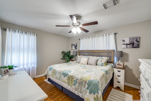 bedroom featuring a textured ceiling, ceiling fan, and dark hardwood / wood-style flooring