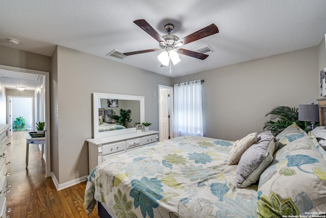 bedroom featuring a textured ceiling, dark hardwood / wood-style floors, and ceiling fan