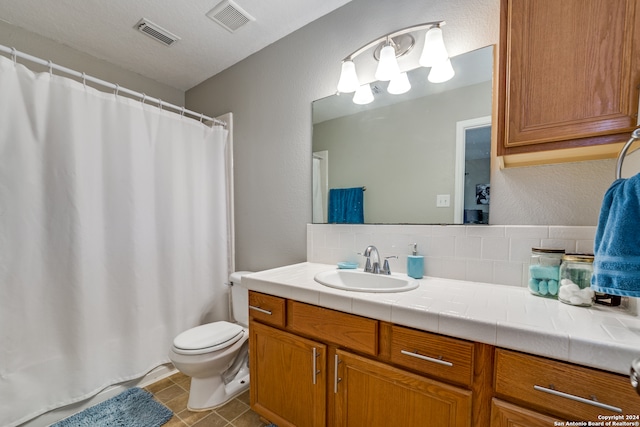 bathroom featuring decorative backsplash, tile patterned floors, vanity, and toilet