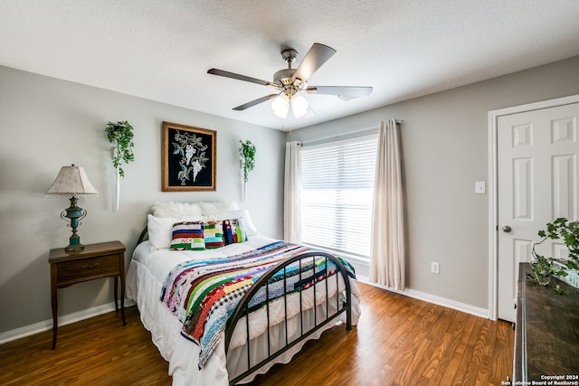 bedroom featuring a textured ceiling, dark hardwood / wood-style flooring, and ceiling fan