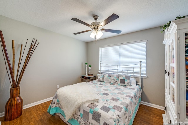 bedroom with a textured ceiling, wood finished floors, baseboards, and a ceiling fan