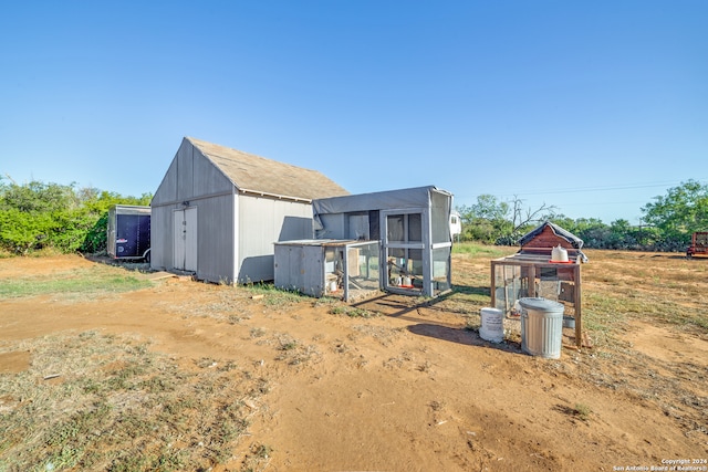 rear view of house featuring an outbuilding