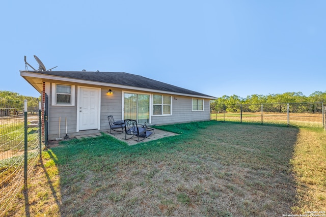 rear view of property featuring a lawn and a patio