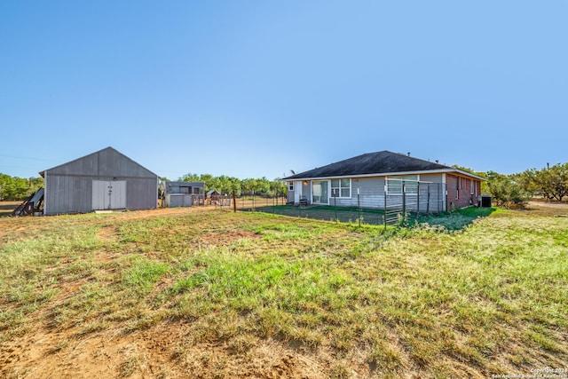 view of yard featuring fence and an outbuilding