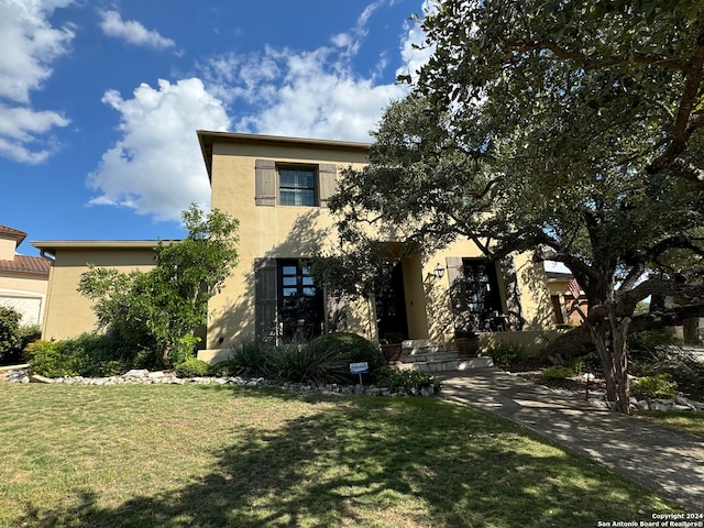 view of front of home with a front yard and stucco siding