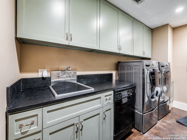 clothes washing area featuring separate washer and dryer, sink, and cabinets