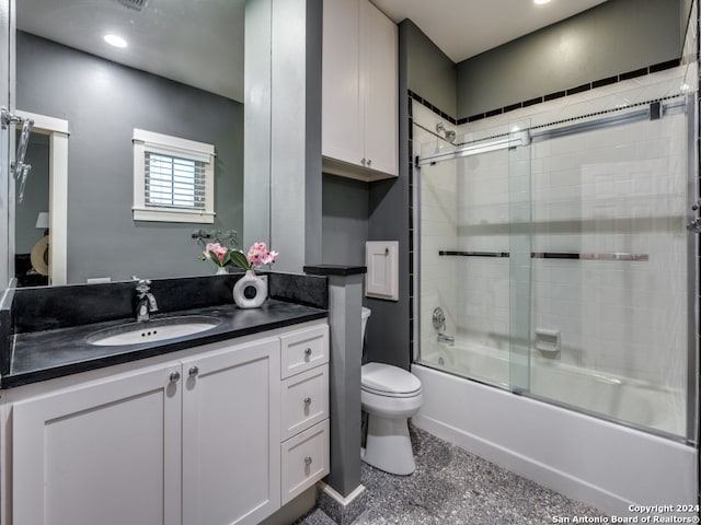 full bathroom featuring enclosed tub / shower combo, vanity, and toilet