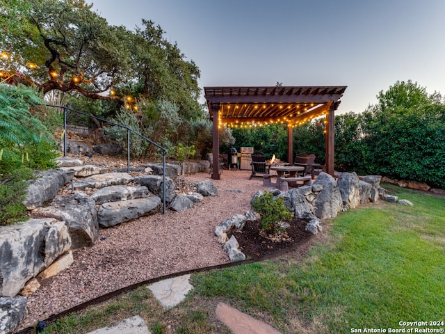 yard at dusk featuring an outdoor fire pit, a pergola, and a patio area