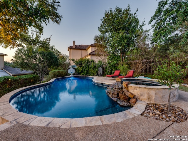 view of swimming pool with an in ground hot tub