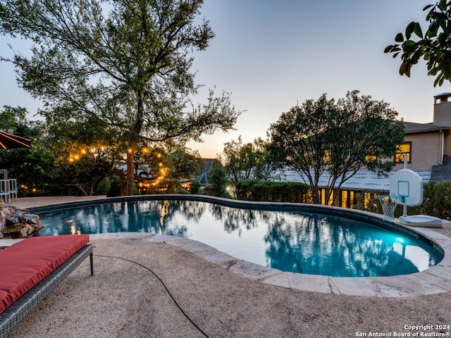 pool at dusk with a patio