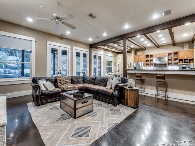 living room featuring concrete floors, french doors, beam ceiling, and ceiling fan