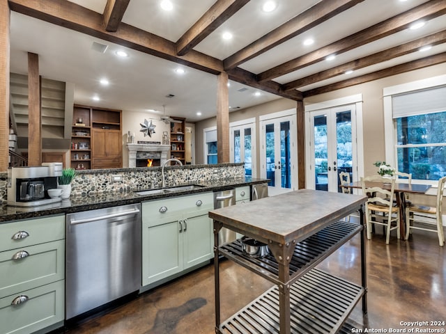 kitchen featuring green cabinetry, stainless steel dishwasher, french doors, dark stone countertops, and sink