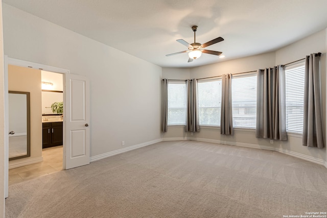 carpeted spare room featuring ceiling fan