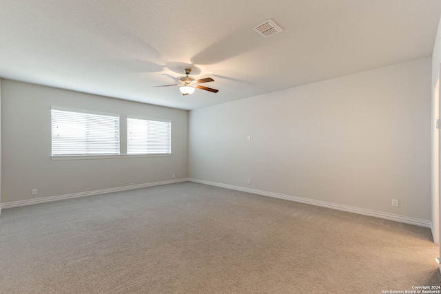 carpeted spare room featuring ceiling fan