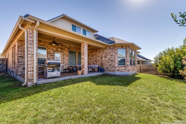 back of house with ceiling fan, a yard, and a patio